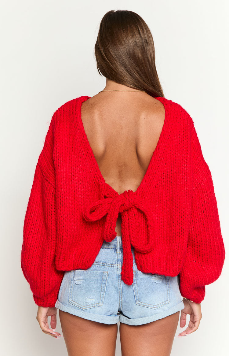 Rear view of a red chunky knit cardigan featuring a deep V-back and a tie-up bow detail