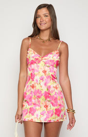 Front view of a honey yellow floral mini dress with a ruched sweetheart bust and thin spaghetti straps