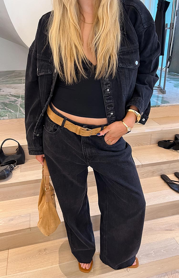 Washed black oversized denim jacket worn open, showing the relaxed fit and frayed hem