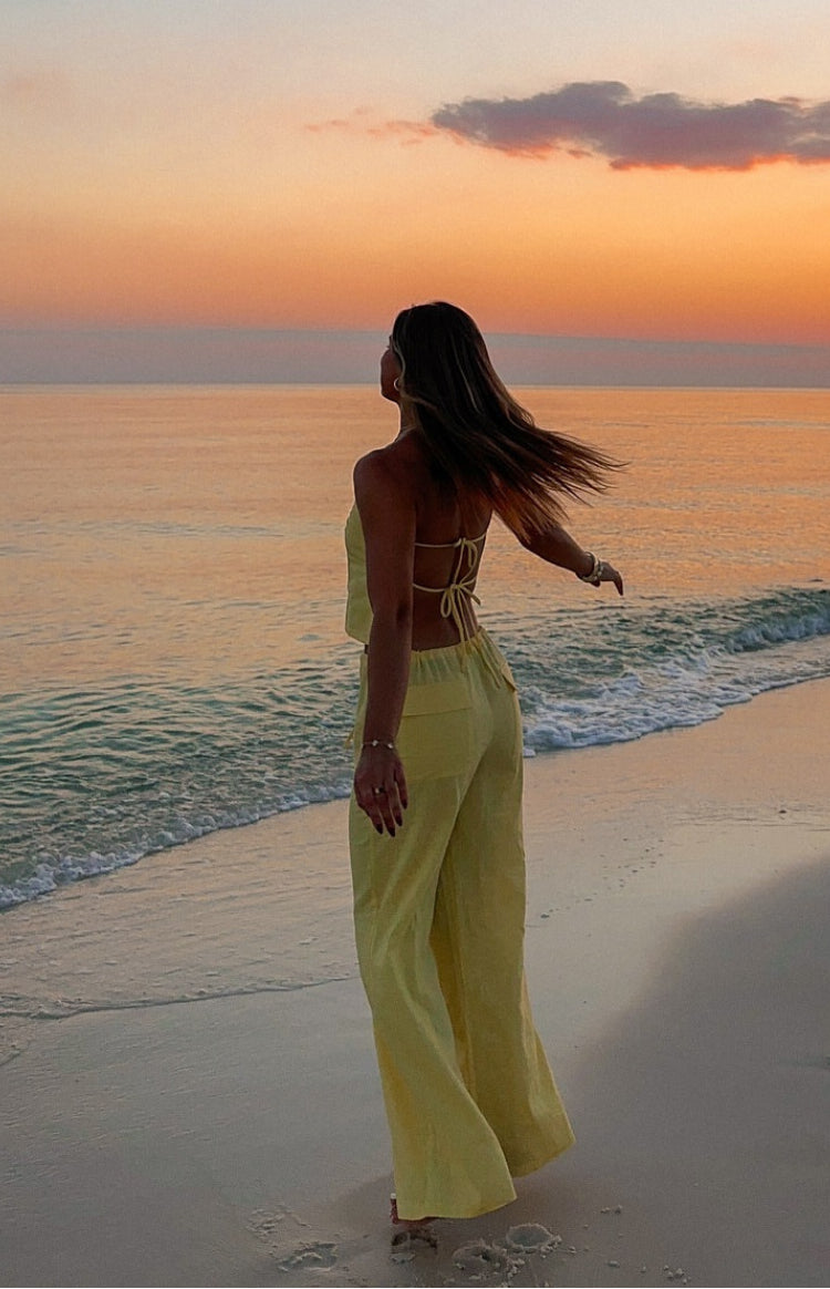 Yellow wide-leg pants with a relaxed fit and drawstring waist, made from a lightweight fabric