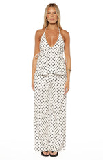 White polka dot halter neck top with deep V-neckline, sleeveless design, and adjustable side ties