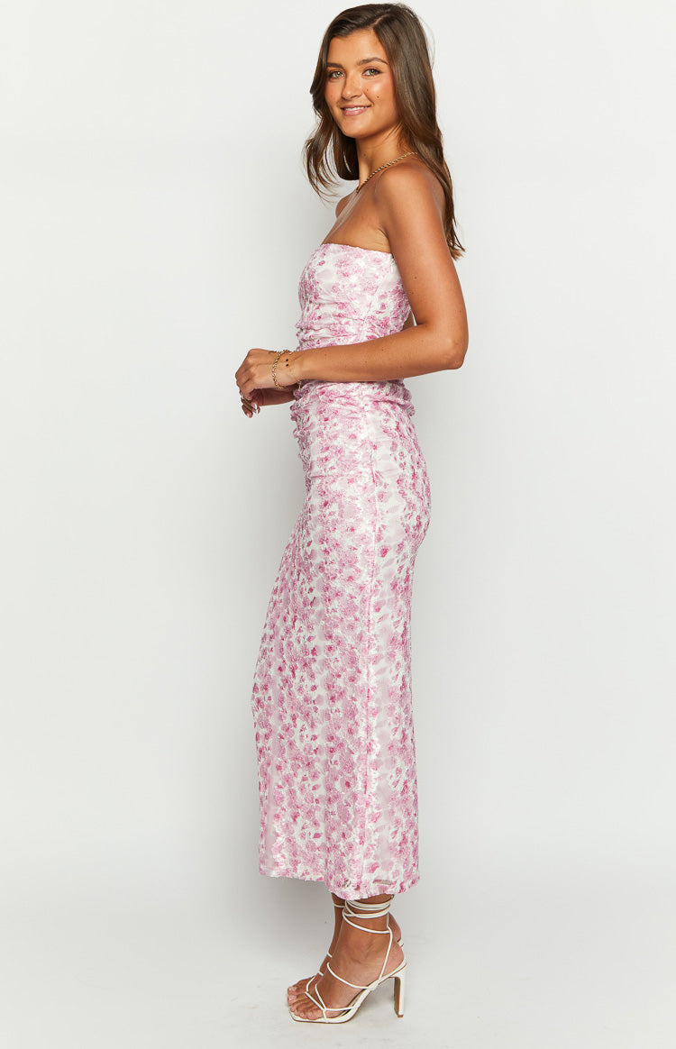 Side view of a pink floral print strapless maxi dress with ruched detailing and a bodycon fit