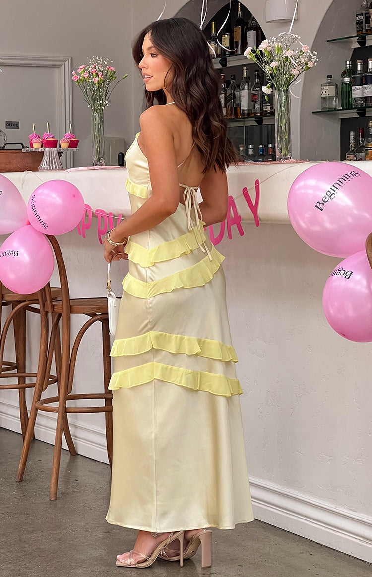 Rear view of a yellow satin maxi dress with criss-cross tie-up back and tiered ruffles