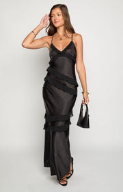 Black crinkled satin maxi dress with a V-neck, thin straps, tiered sheer ruffles, and a side leg slit