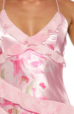 Close-up of the pink satin V-neckline with sheer ruffles and pink floral print on a maxi dress