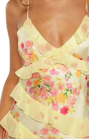 Detail of the yellow floral print maxi dress with a ruffle-trimmed V-neckline and tiered ruffles
