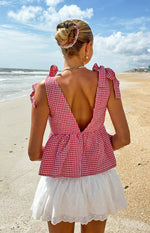 Back view of a white broderie mini skirt with a scalloped hem and intricate floral eyelet pattern