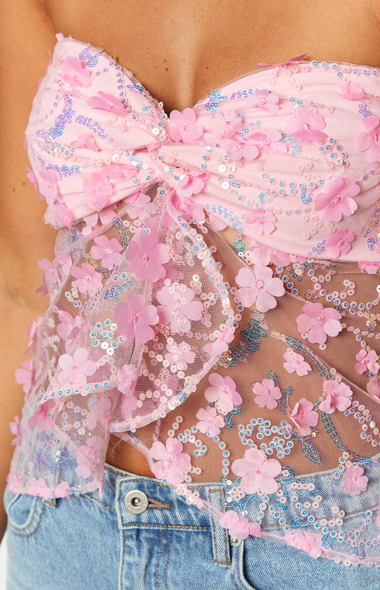 Close-up of the pink sequin strapless top with 3D floral appliques and a bow detail at the bust