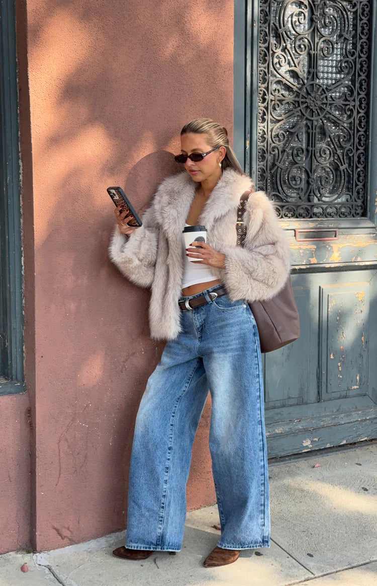 Sand faux fur jacket with wide lapels, a fluffy texture, and a slightly cropped fit