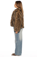 Side view of a chocolate brown striped faux fur jacket with a relaxed, cropped fit