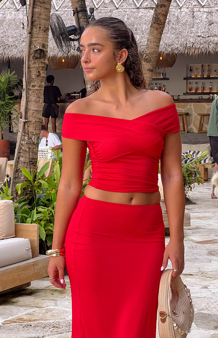 Front view of the red off-shoulder crop top with a crossover bust and ruched detailing on the sides