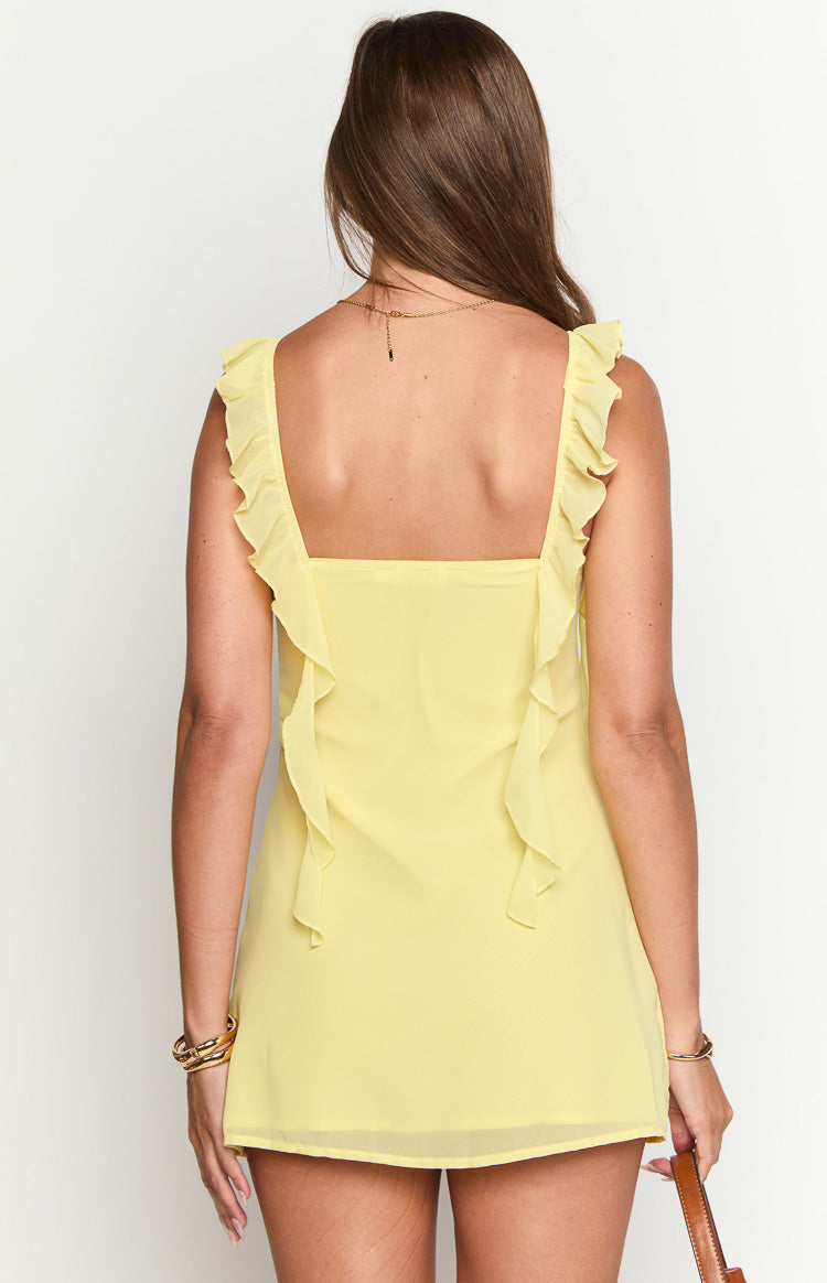 Rear view of a yellow chiffon mini dress with a square back and ruffled straps extending down the back