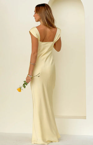Rear view of a yellow satin maxi dress with a square back neckline and short cap sleeves