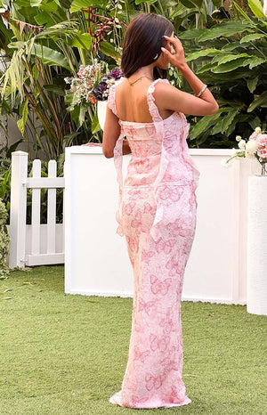 Full back view of a pink maxi skirt with an all-over embroidered butterfly pattern and a fitted silhouette