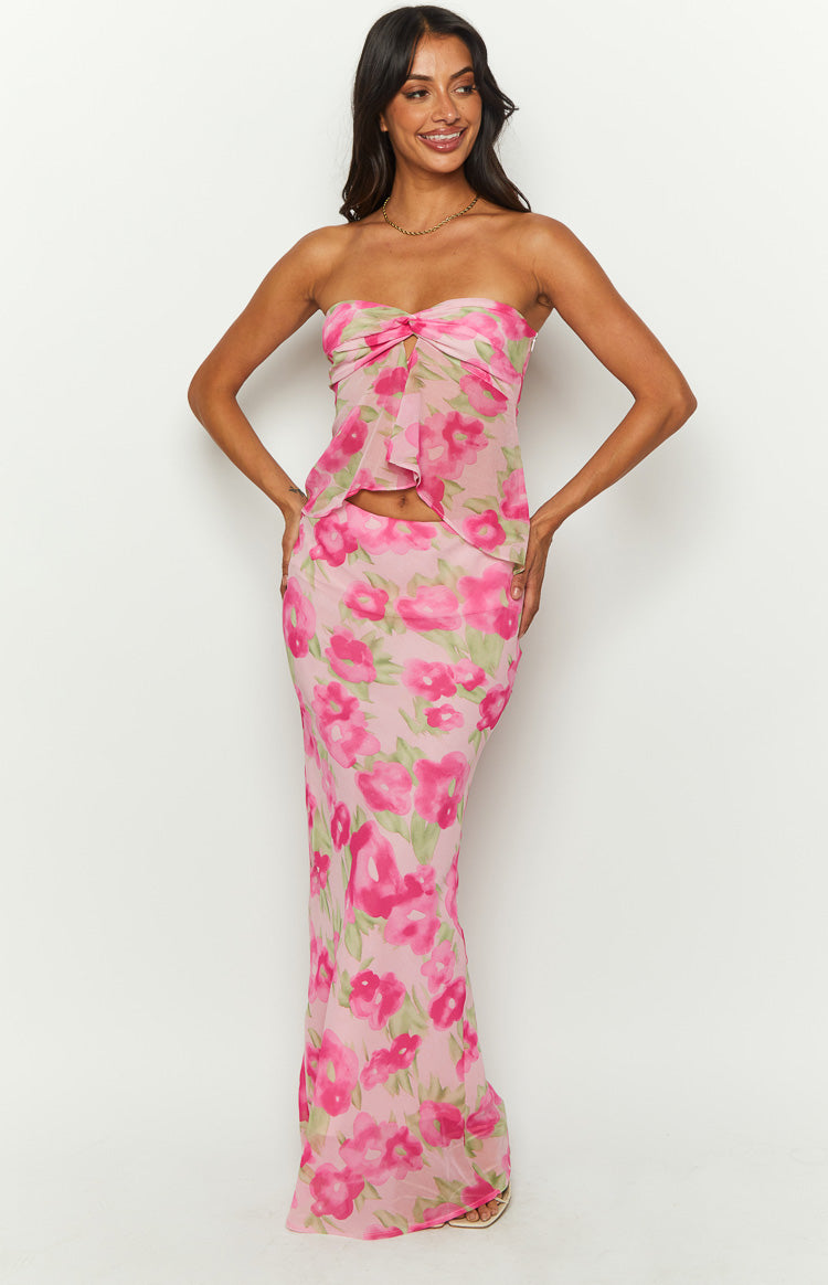 Front view of a sheer pink floral print maxi skirt, fitted through the hips with a flowing hem