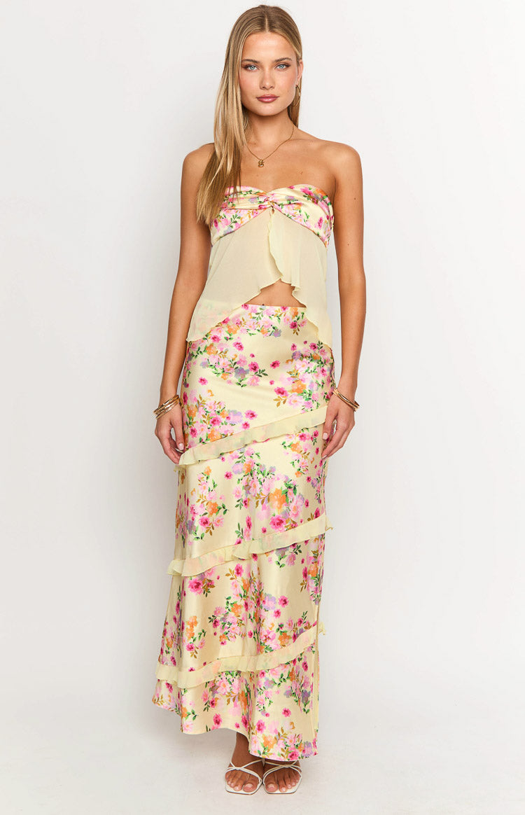 Rear-side view of a strapless top with a yellow floral print band and sheer light yellow flowy body