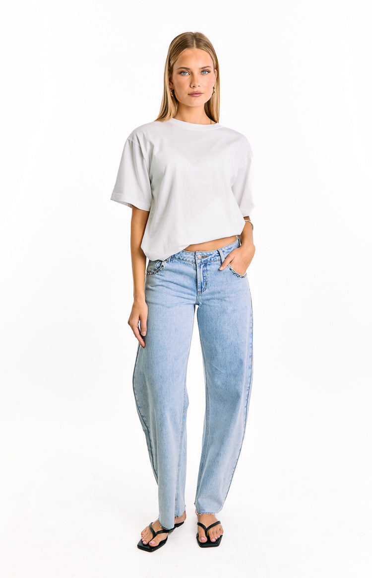 Front view of light wash denim low rise jeans with a relaxed wide leg fit and studded detailing