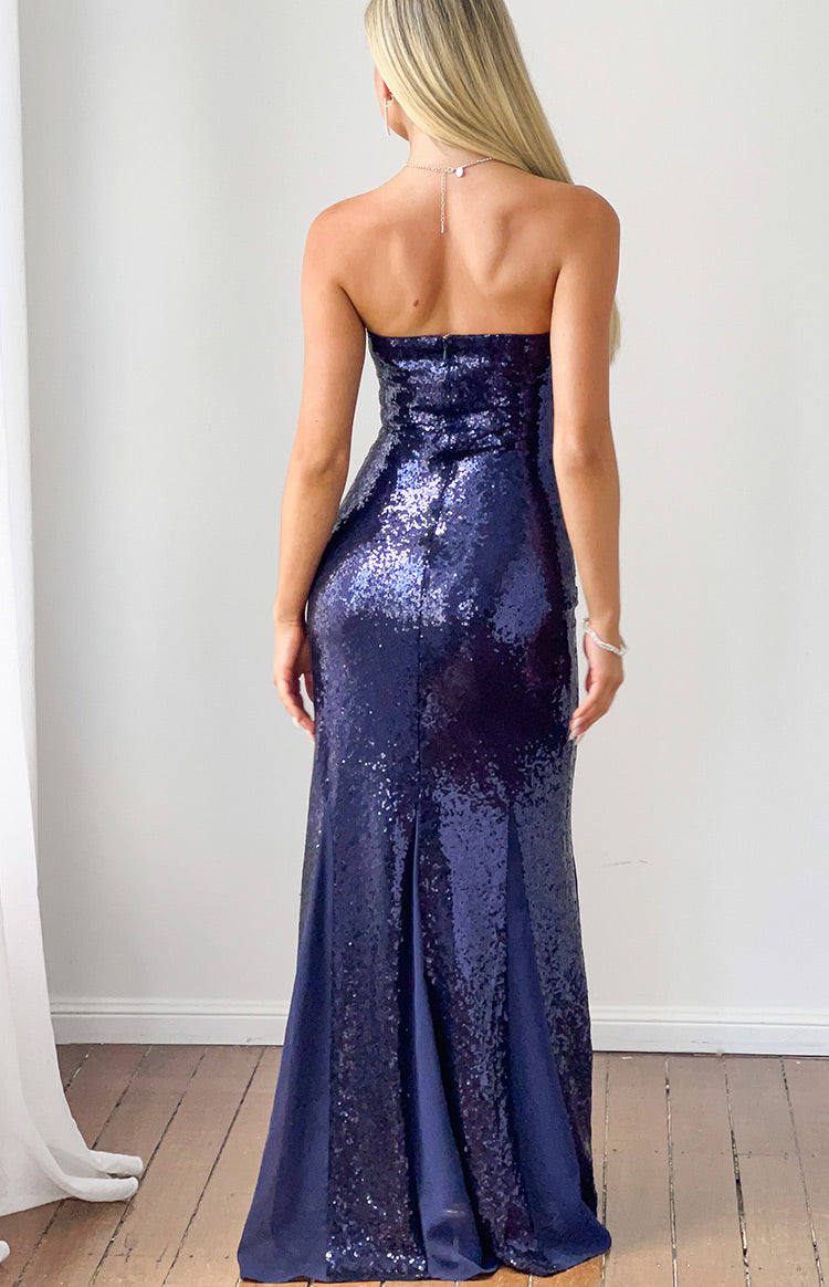 Rear view of a navy sequin strapless maxi dress with a back zipper and a flared hem revealing plain navy fabric