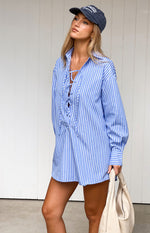 Relaxed fit blue pinstripe mini shirt dress with a collared lace-up V-neck and long sleeves
