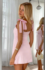 Rear view of a baby pink mini dress showing the wide tie-shoulder straps and square back