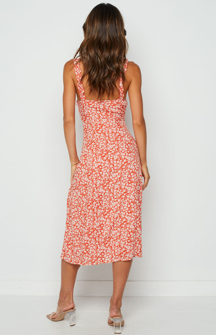 Rear view of an orange floral print midi dress with a square back neckline and thin shoulder straps
