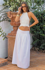 White maxi skirt with a gathered waist and visible side tie detail, flowing to the floor