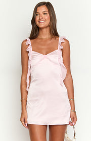 Pink satin mini dress with a sweetheart neckline, bow detail at the bust, and ruffled sheer organza straps