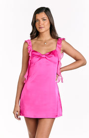 Front view of a hot pink satin mini dress with a sweetheart neckline, bow detail, and ruffled organza straps