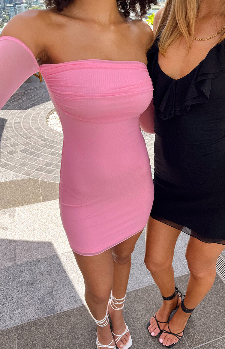 Close-up of a pink off-the-shoulder mini dress with ruched mesh bust and sheer long sleeves