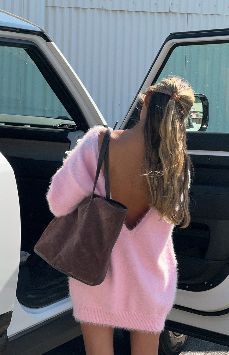 Rear view of a pink fuzzy knit mini dress with a deep V-back