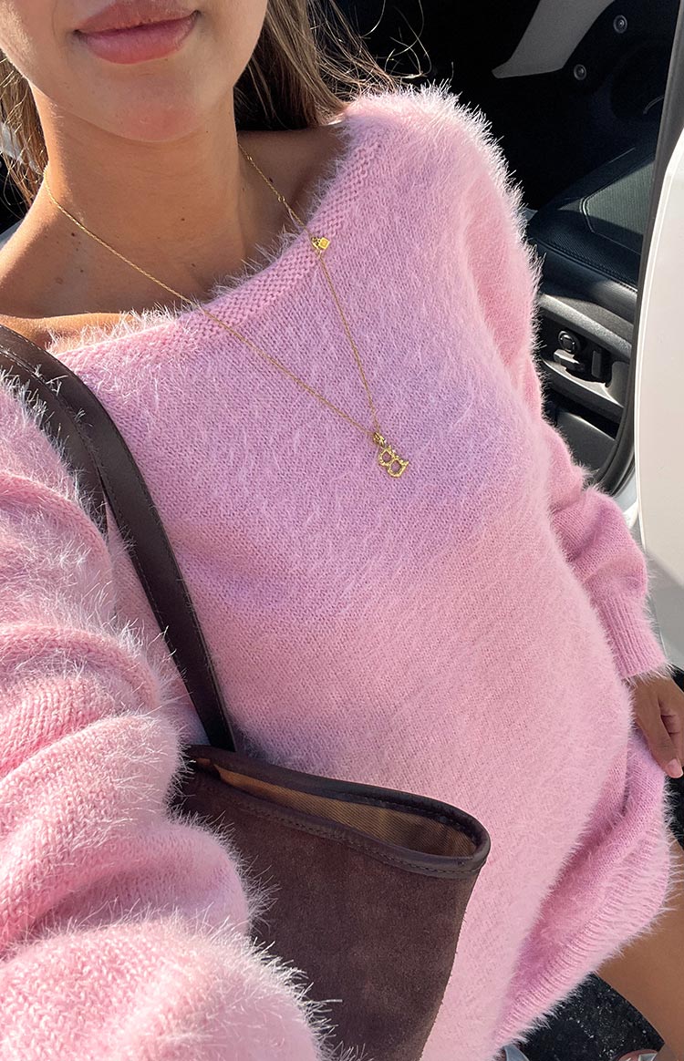 Close-up of the fuzzy pink knit mini dress with a wide boat neckline and long sleeves