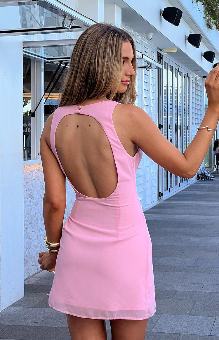 Rear view of a pink mini dress with a large oval back cutout and a single button closure at the neck