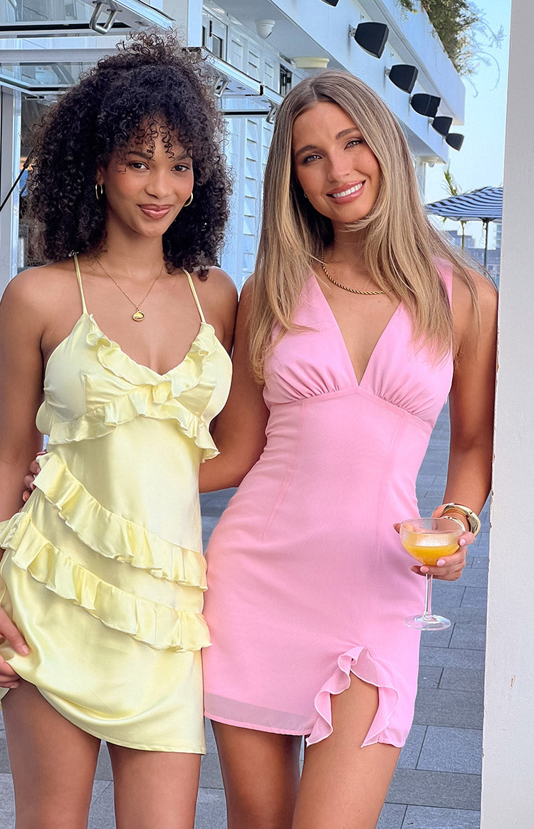 Pink sleeveless V-neck mini dress with a ruched bust, empire waist, and ruffled side slit