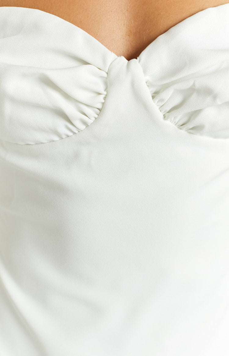 Close-up of the white mini dress showing the twisted knot detail at the center of the sweetheart neckline