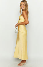 Side view of a yellow satin strapless maxi dress with side waist cutouts and a flowy skirt