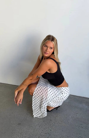 White polka dot midi skirt with a draped hanky hem and flowy fabric