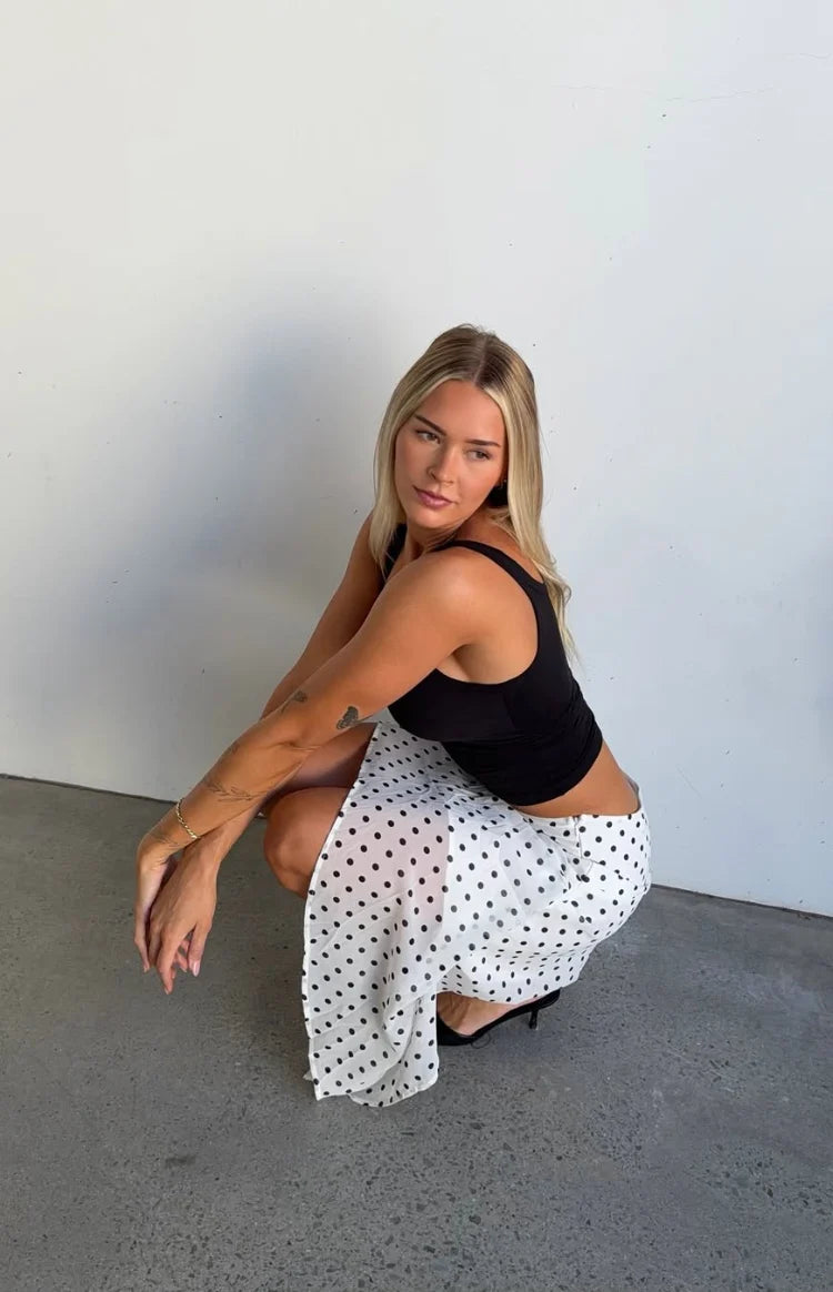 White polka dot midi skirt with a draped hanky hem and flowy fabric
