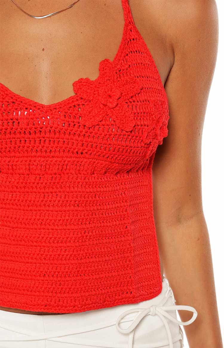 Close-up of the red crochet halter top, highlighting the textured knit and 3D flower detail on the bust
