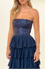 Close-up of the navy strapless sequin bodice and tiered ruffle skirt of the maxi dress