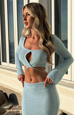 Close-up of the light blue knit top with a square neckline, large bust cutout, and wrap-around tie detail