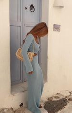Side view of the light blue long sleeve knit top showing its cropped fit and knit texture