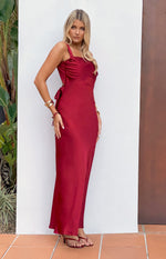 Side view of a wine satin maxi dress with a square neckline, ruched bust, side cutouts, and waist ties