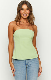 Front view of a lime green strapless top with a fitted bodice and subtle peplum hem