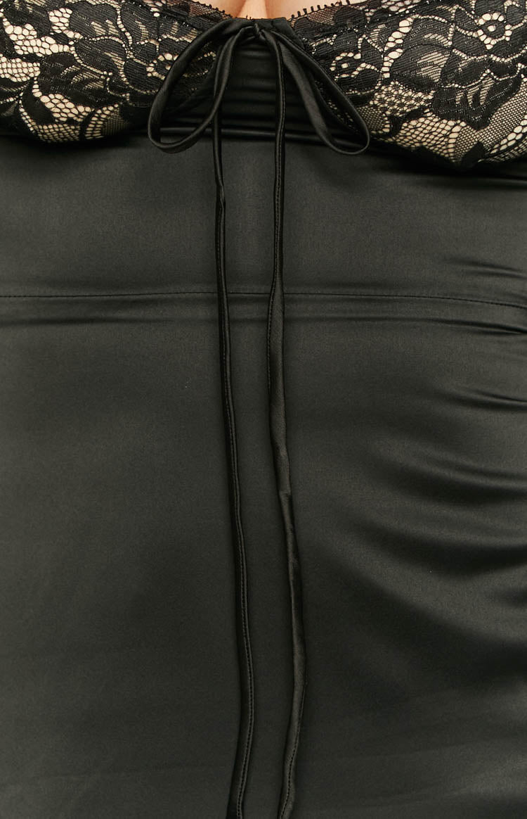 Close-up of the black lace bust with beige lining and a central drawstring tie, above the smooth black satin fabric