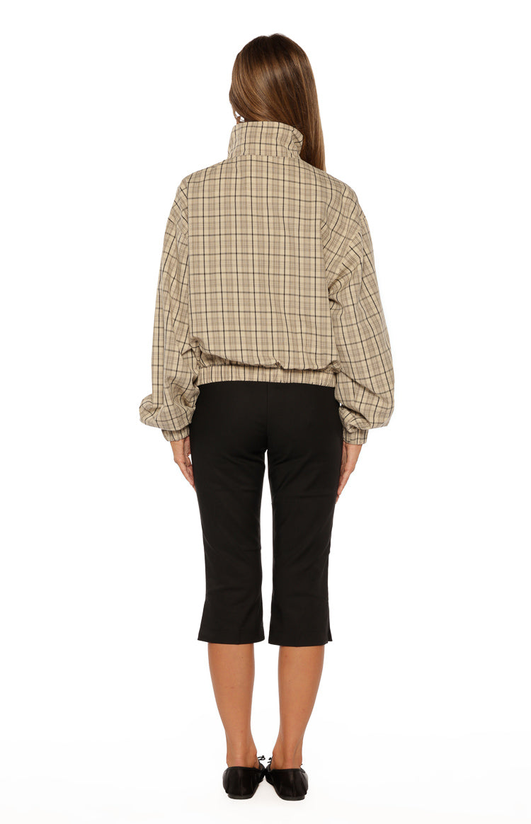 Rear view of the beige plaid jacket with a high funnel neck, voluminous long sleeves, and elasticated waist