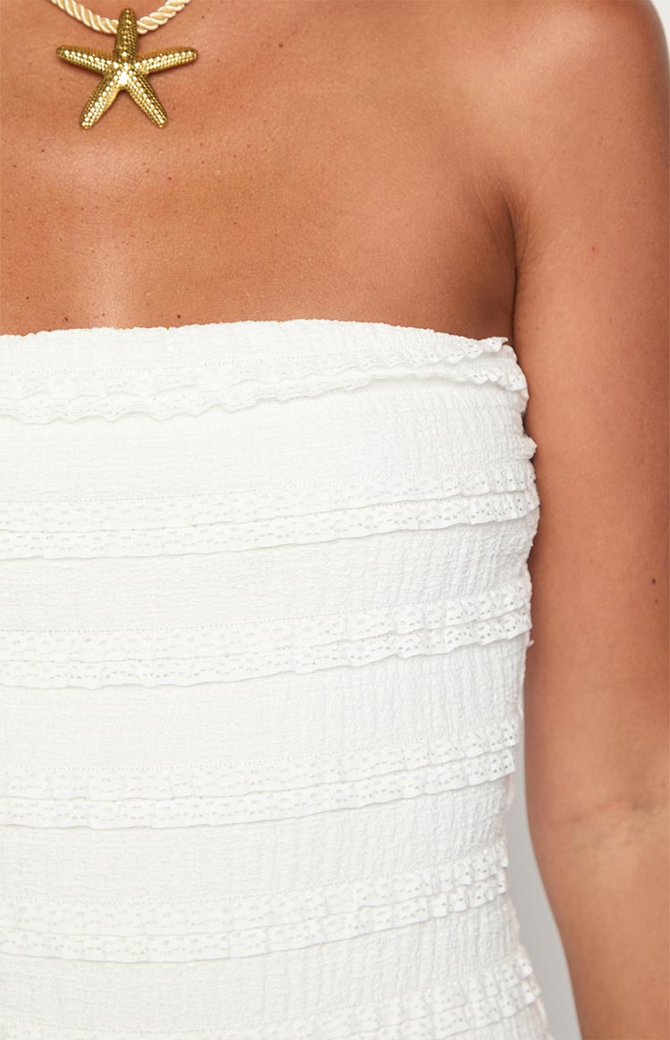 Close-up of the white strapless playsuit showing the shirred bodice with horizontal ruffled lace trim
