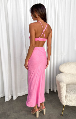 Rear view of a pink maxi dress showing criss-cross adjustable spaghetti straps, elasticated back, and waist cutout