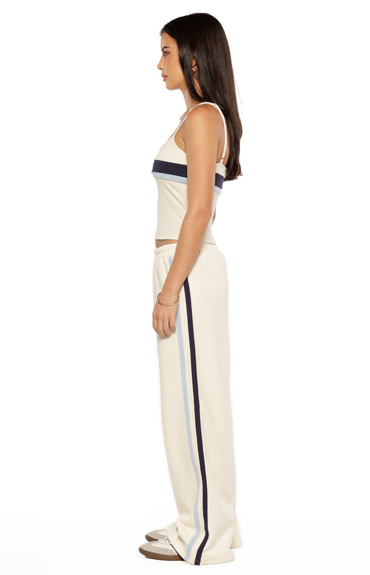 Side view of white relaxed fit pants with navy and light blue vertical stripes down the side seam