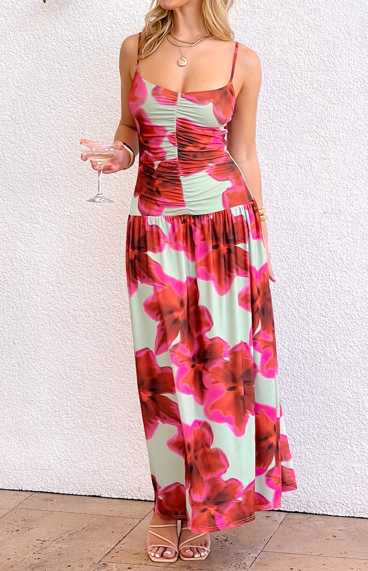 Front view of a green and red floral print maxi dress with a ruched bodice, spaghetti straps, and a gathered waist
