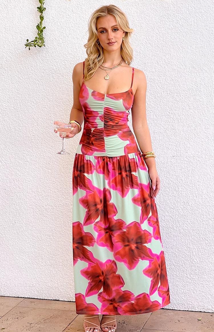 Front view of a light green maxi dress with large pink and red floral print, ruched bodice, and thin spaghetti straps